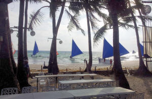 Beach in the Philippines with sail boats on the background 